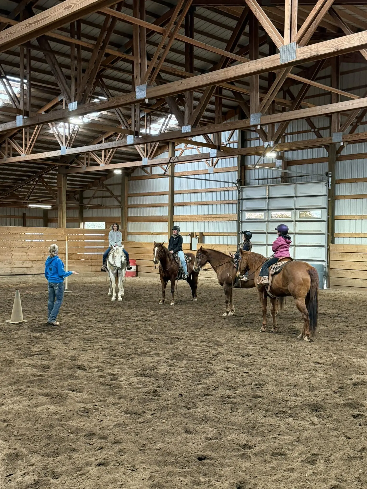 Students riding in a lesson in the indoor arena