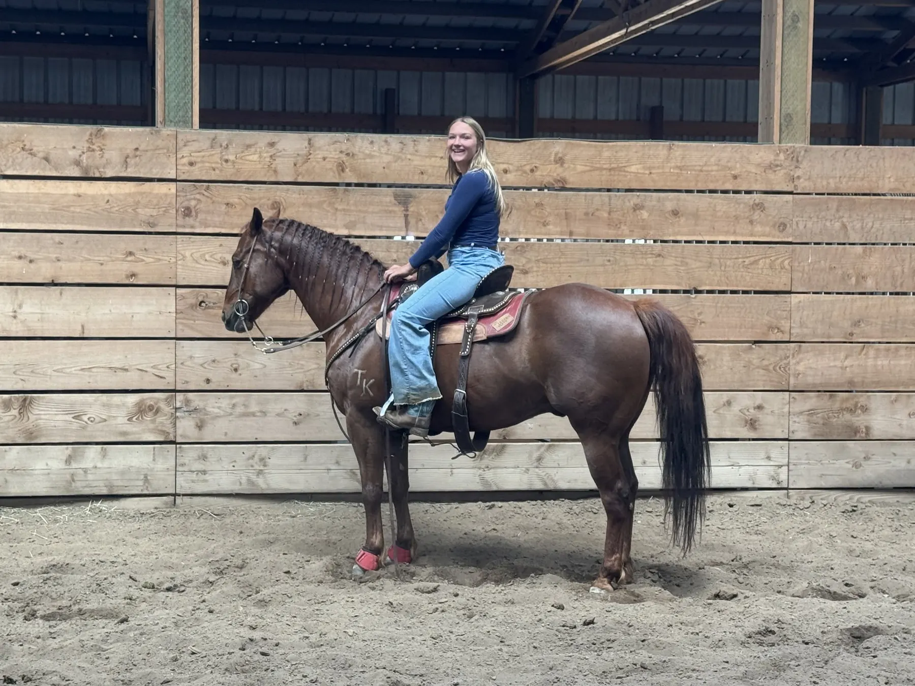 A rider sitting tall on a bay horse in the arena