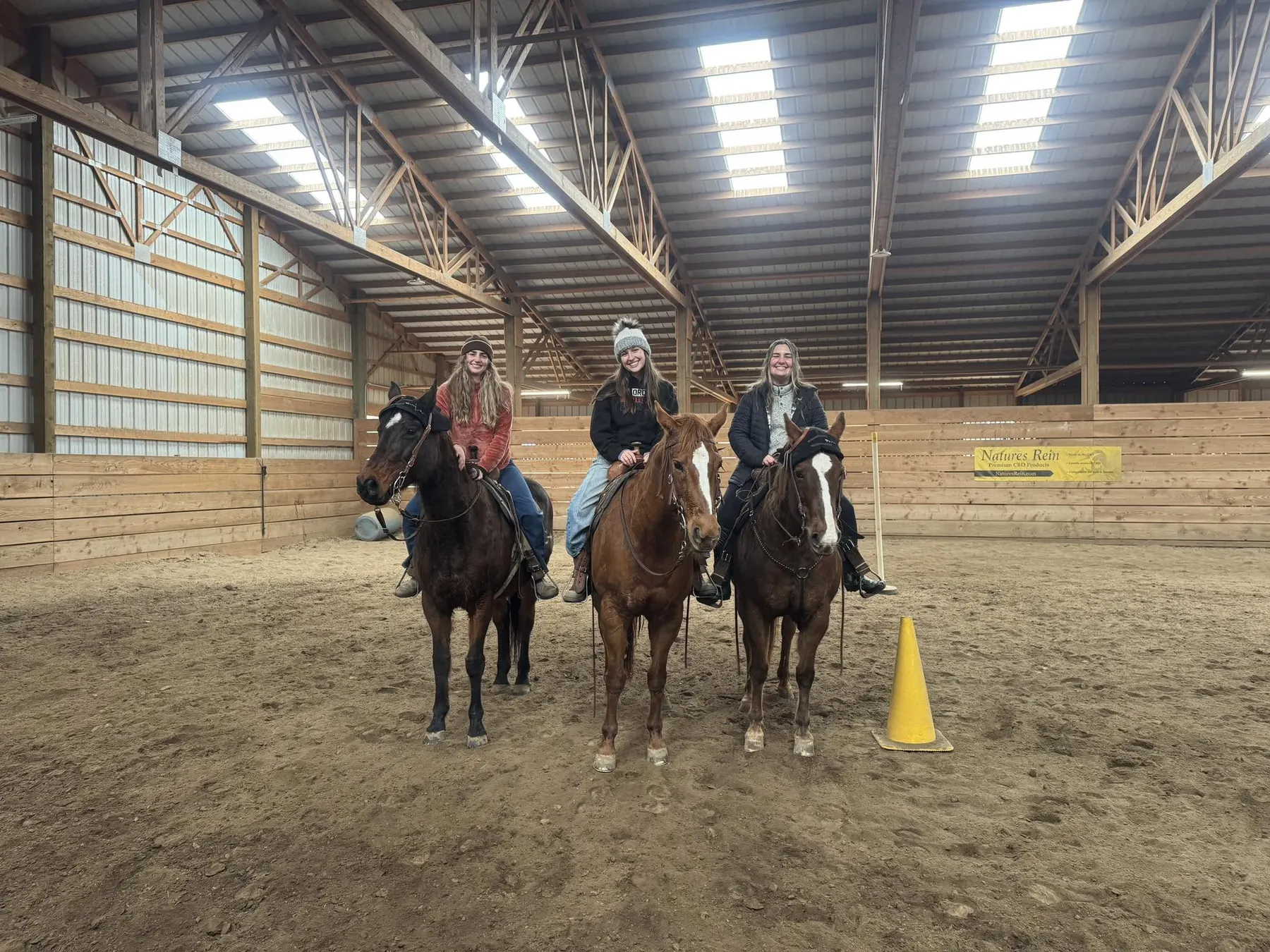 Three riders lined up in the indoor arena